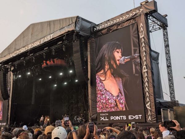 The singer Beabadoobee on a big screen next to the stage.